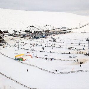 The Lecht community mourns loss of one of its original founders A snow-covered ski resort with skiers on the slopes, a busy car park, and a wooden lodge at the base of the mountain.