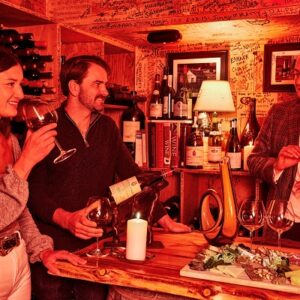 After a day on the slopes, there's still plenty on offer in Aspen Snowmass Three people enjoy wine and a charcuterie board in a candle-lit bar, its walls covered in handwritten messages and lined with wine bottles.