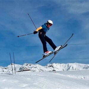 Great spring skiing and snowboarding conditions leads to late surge in bookings A skier in a blue and yellow jacket leaps high above a snowy slope against a clear blue sky.