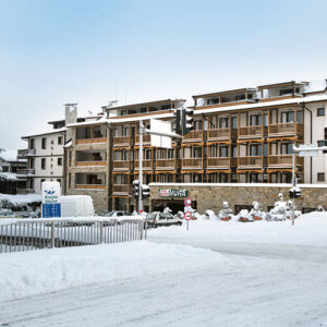 6 Best Holidays for Single Skiers from Iglu Ski Snow-covered MURA apartment buildings with balconies stand behind a snowy road, traffic lights, and frosted trees.