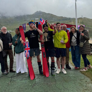 Duo complete 800-mile charity walk in ski boots Group celebrates with red skis, trophy and Union Jack flags at the 'Thorens' event, with spark machines firing.