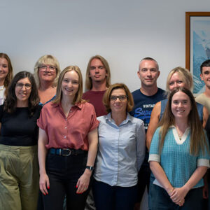 Peak Retreats becomes first employee-owned ski company in UK Eleven people stand smiling together indoors beside a framed Chamonix Mont-Blanc ski poster.